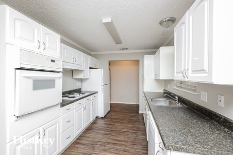 A kitchen with white cabinets and appliances.
