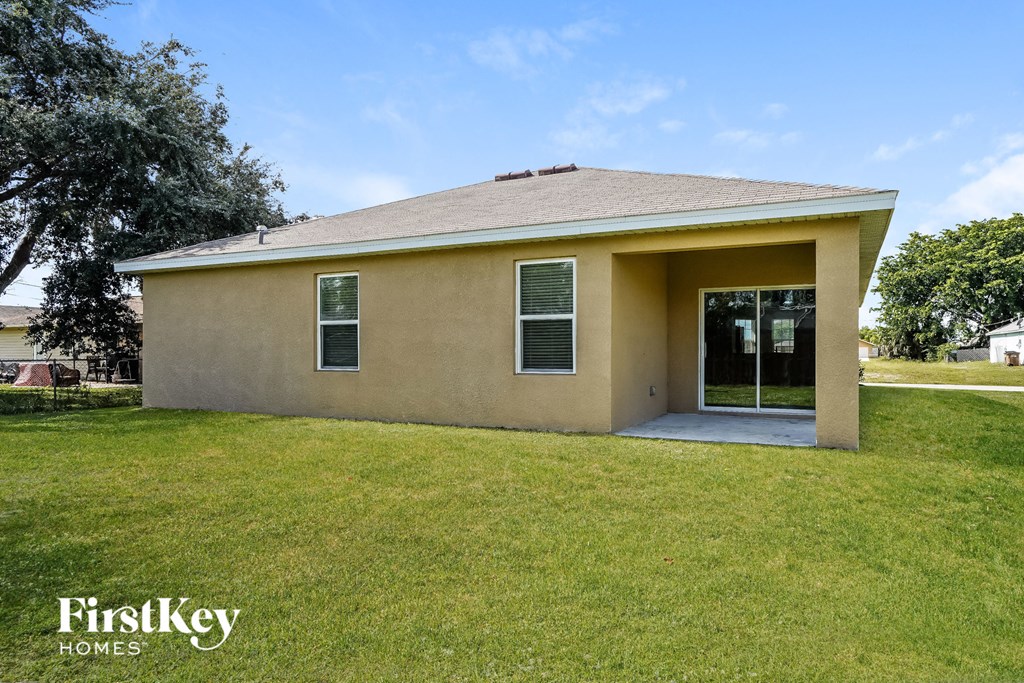A small house with a brown roof and a yellow exterior is for sale.