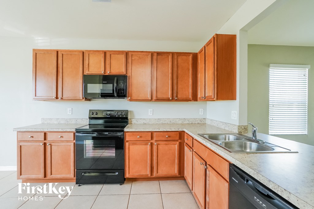 A kitchen with brown cabinets and a black oven.