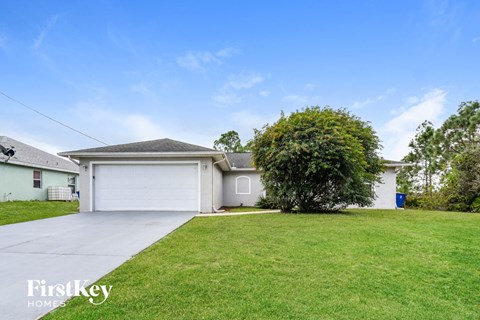 a white house with a lawn and a white garage door