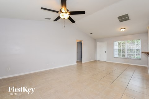 the living room is spacious and clean with a ceiling fan