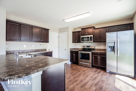 A kitchen with brown cabinets and a granite countertop.