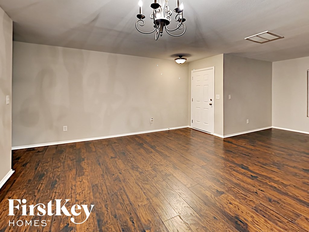 A room with wooden floors and a chandelier.