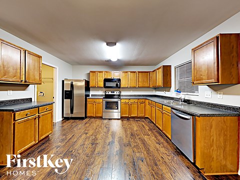 A kitchen with wooden cabinets and a refrigerator.