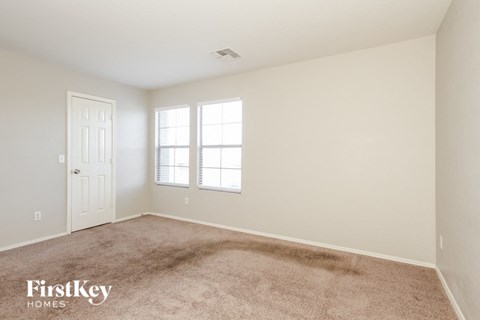 a bedroom with carpet and a white door and window