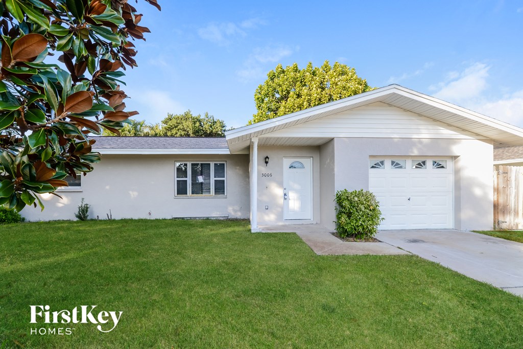 a white house with a lawn and a white garage door