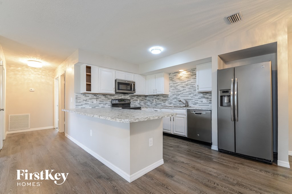 a kitchen with stainless steel appliances and a marble counter top