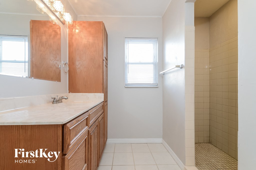 a bathroom with a shower and a sink and a mirror