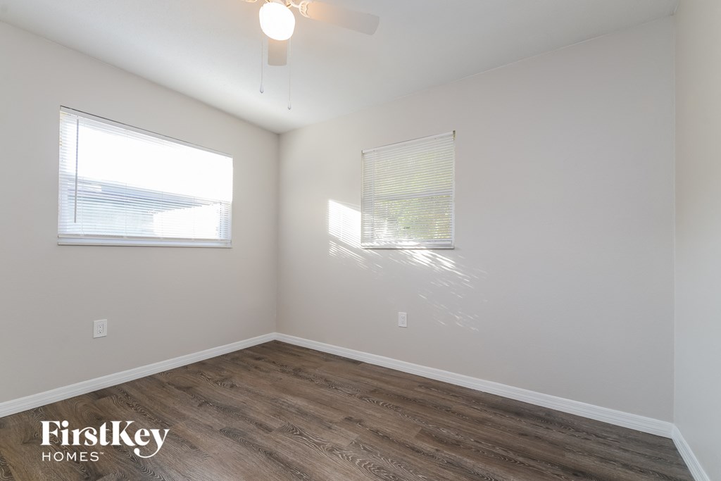 the living room with wood flooring and two windows