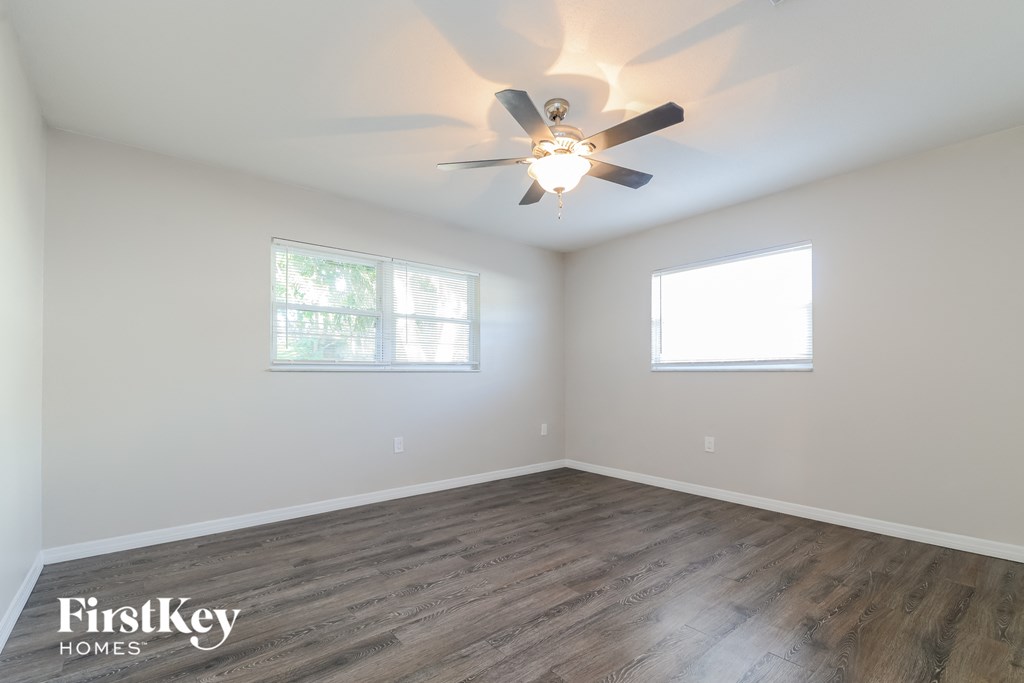 a living room with wood flooring and a ceiling fan