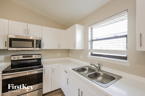 A kitchen with a stove top oven and a microwave.