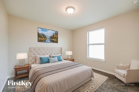 A bedroom with a large bed and a painting on the wall.