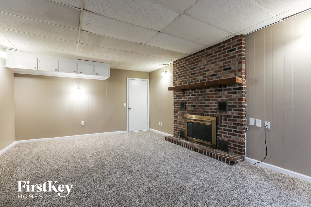 A room with a fireplace and a carpeted floor.
