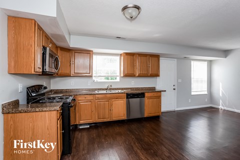 A kitchen with wooden cabinets and a stove top oven.