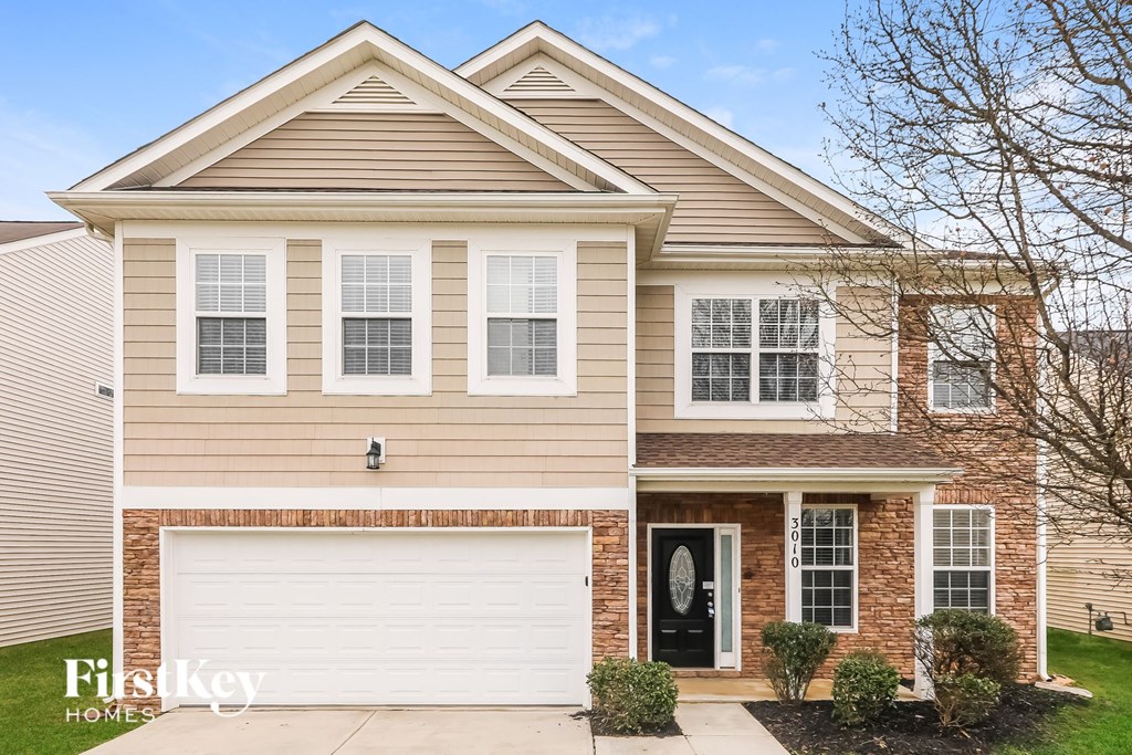 a tan house with a white garage door