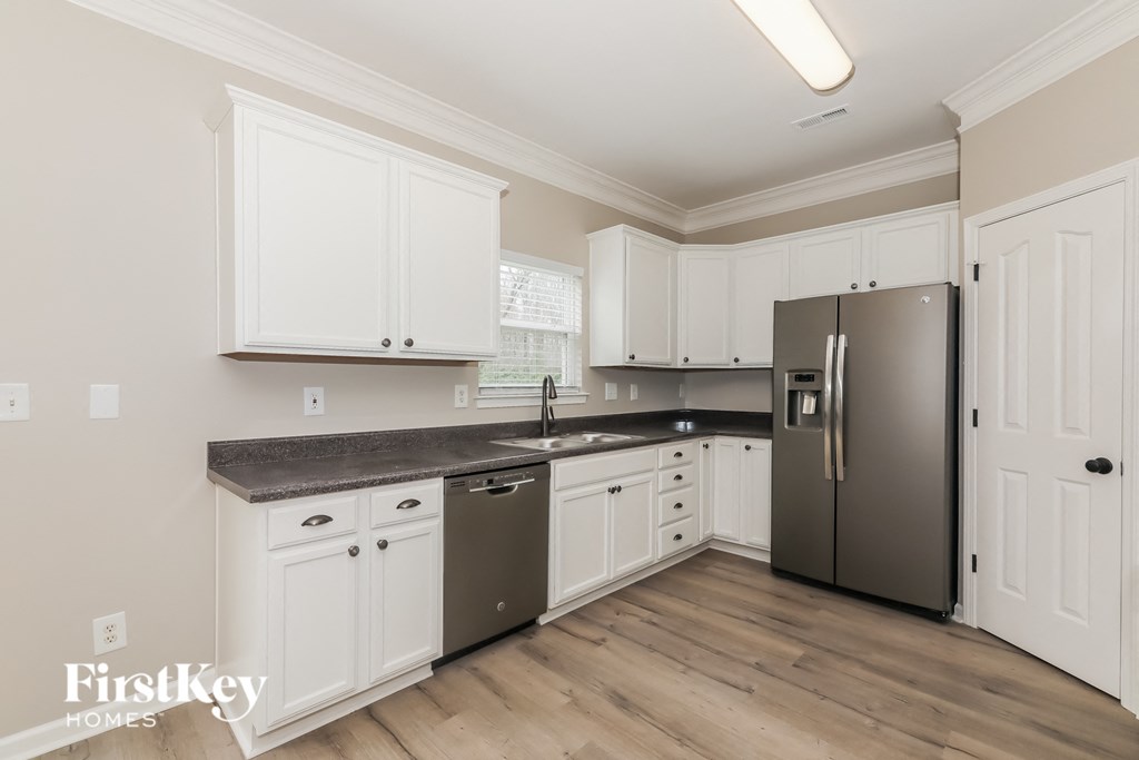 a kitchen with white cabinets and a stainless steel refrigerator
