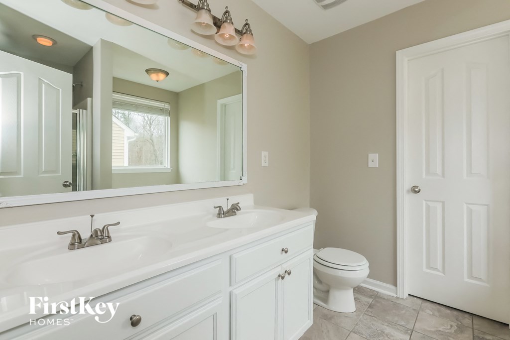 a bathroom with a large mirror and a sink and a toilet