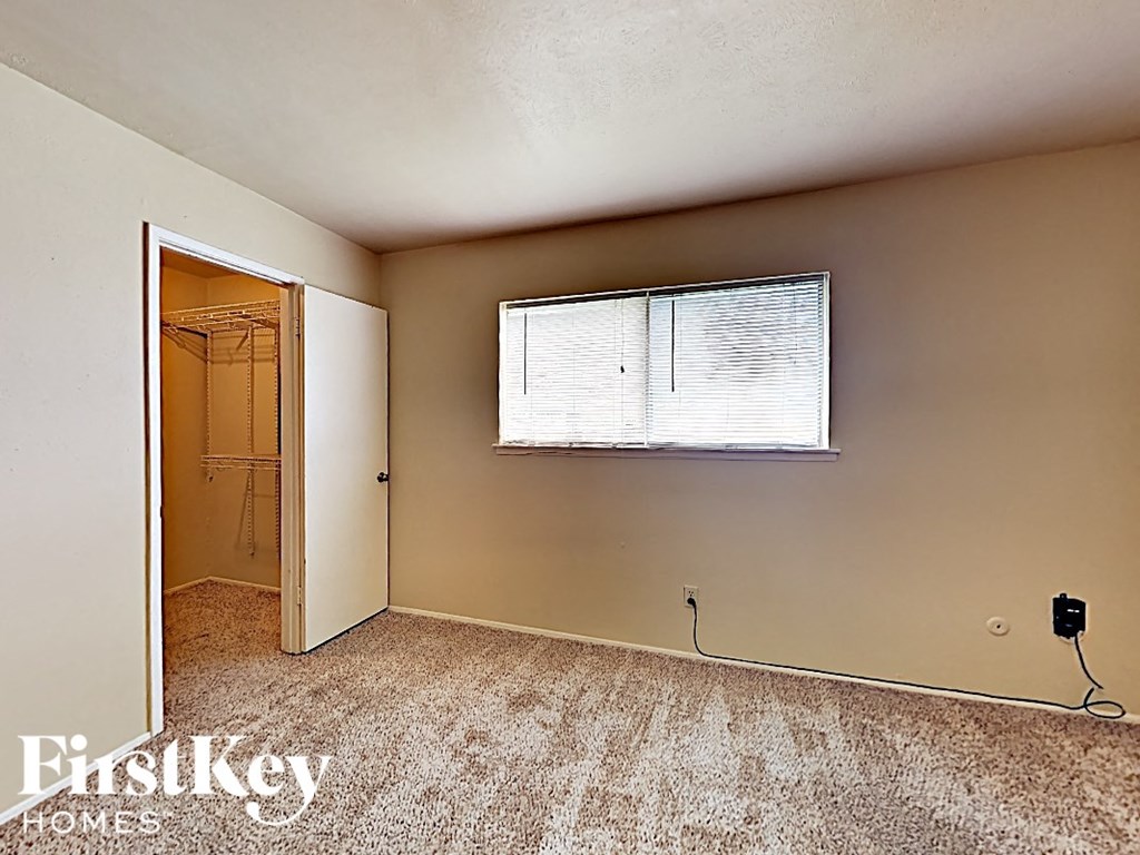 the bedroom of an empty house with a window and a closet
