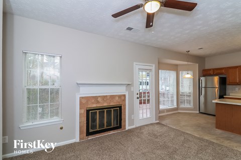 a living room with a fireplace and a kitchen