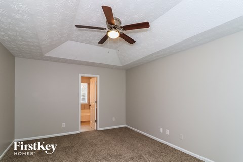 the master bedroom has a ceiling fan and gray walls