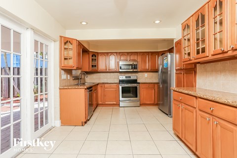 A kitchen with orange cabinets and a refrigerator.
