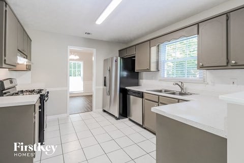 a white kitchen with stainless steel appliances and white counter tops