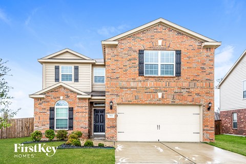 a brick house with a white garage door in front of it