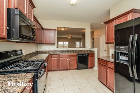full view of the kitchen with granite countertops and black appliances