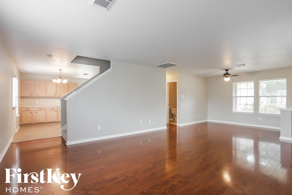 an empty living room with wood flooring and white walls