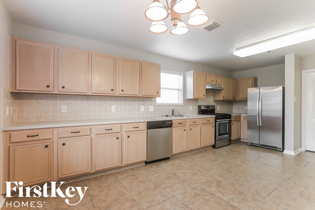 a kitchen with wooden cabinets and stainless steel appliances