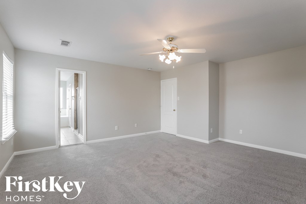 a bedroom with carpet and a ceiling fan