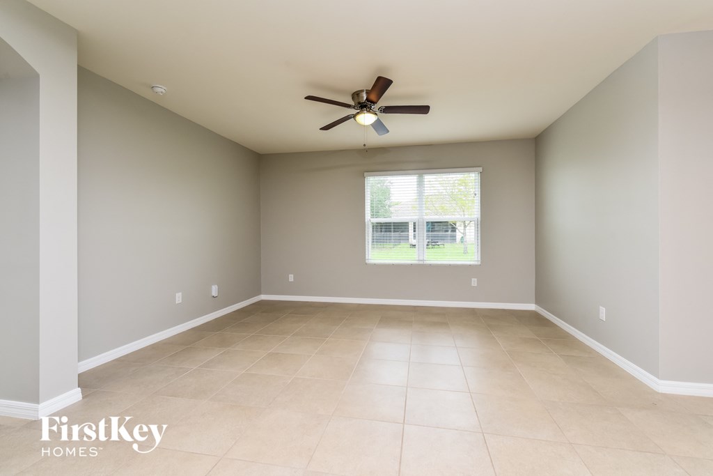 an empty room with a ceiling fan and a window