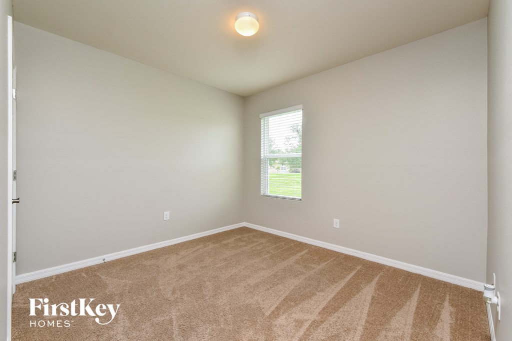 an empty room with carpet and a window