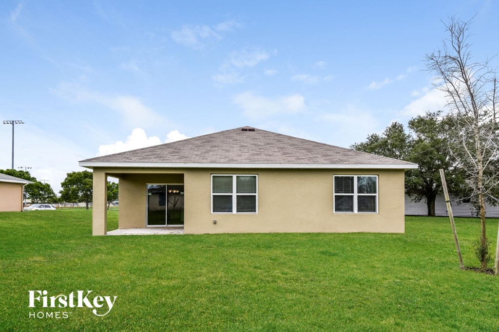 a small tan house in a grassy yard