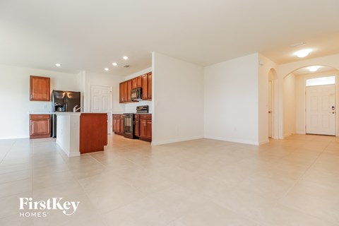A spacious kitchen with wooden cabinets and a refrigerator.