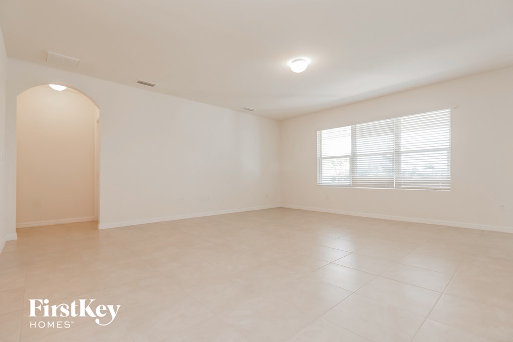 A spacious empty room with a window and a door.