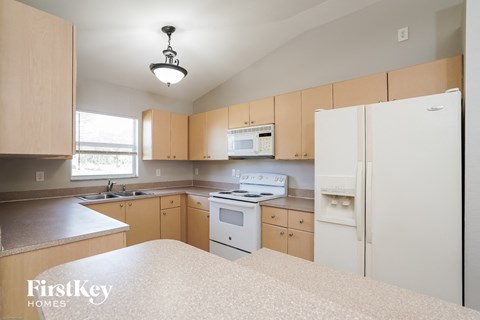 a kitchen with white appliances and wooden cabinets