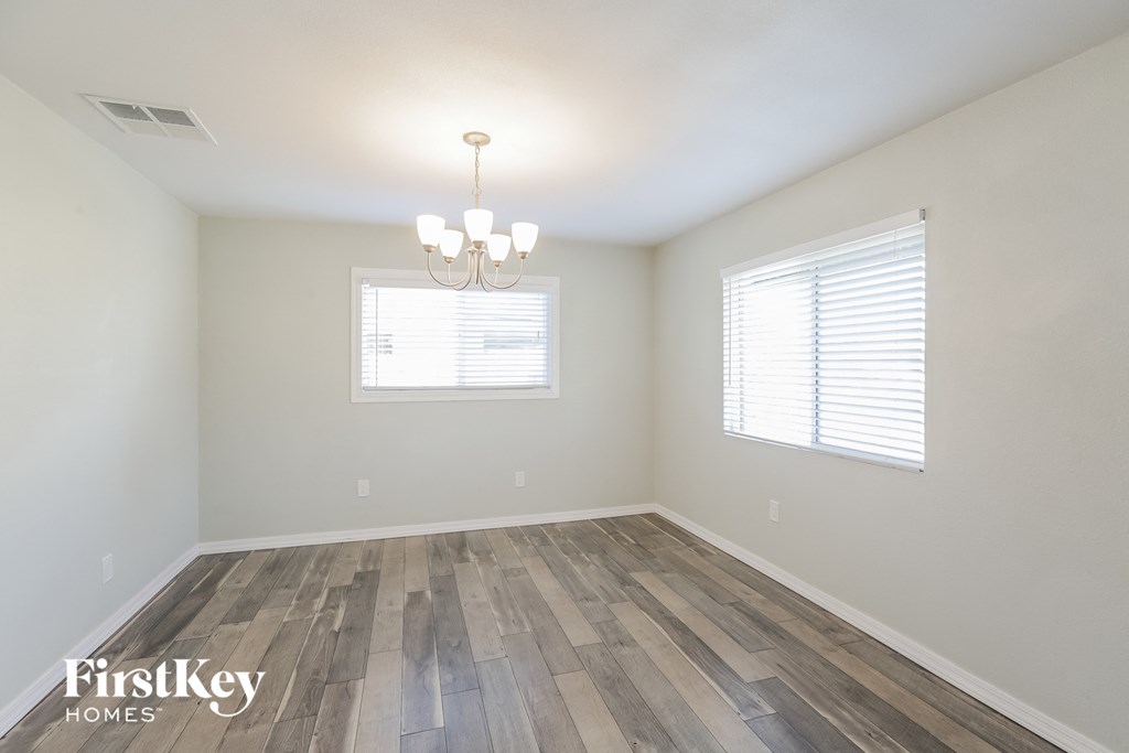 the spacious dining room with wood flooring and a chandelier