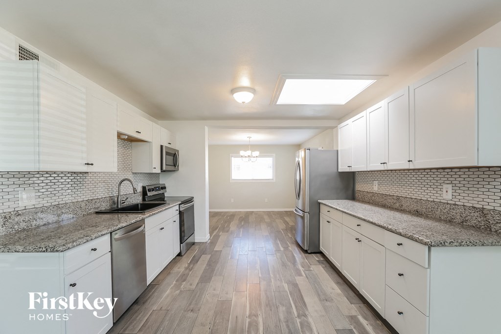 a kitchen with white cabinets and stainless steel appliances