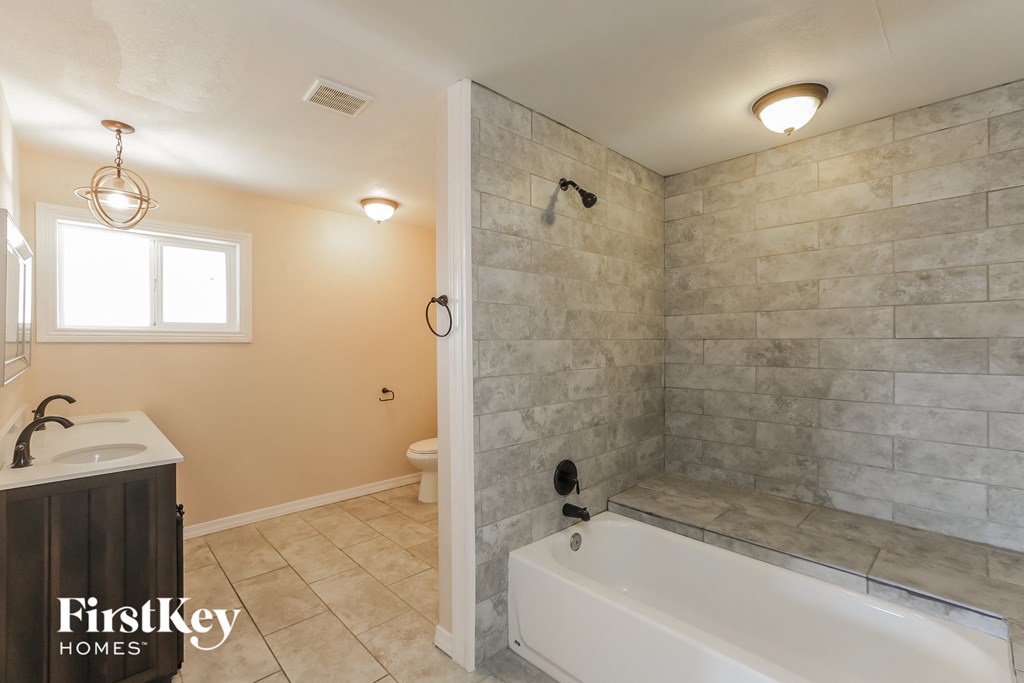 a bathroom with a tub and a sink and a toilet