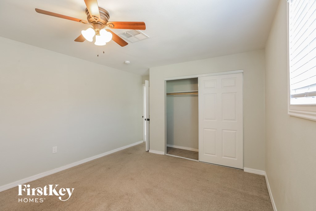 a bedroom with a closet and a ceiling fan