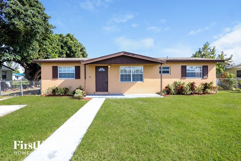 a beige house with a lawn and a sidewalk