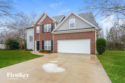 a brick house with a white garage door on a driveway