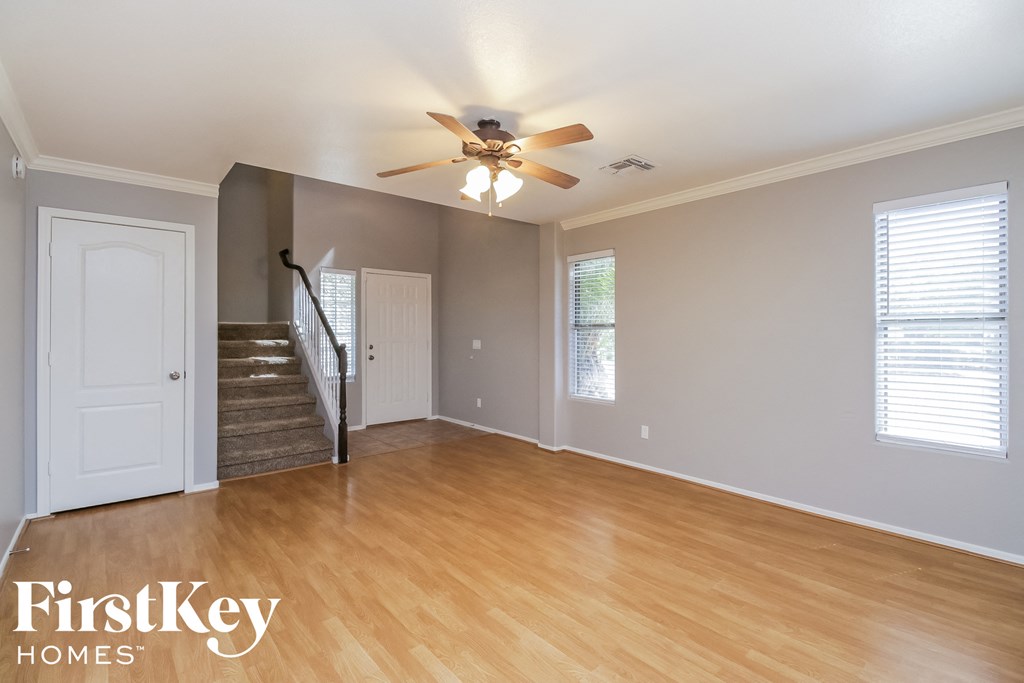 a living room with wood flooring and a ceiling fan
