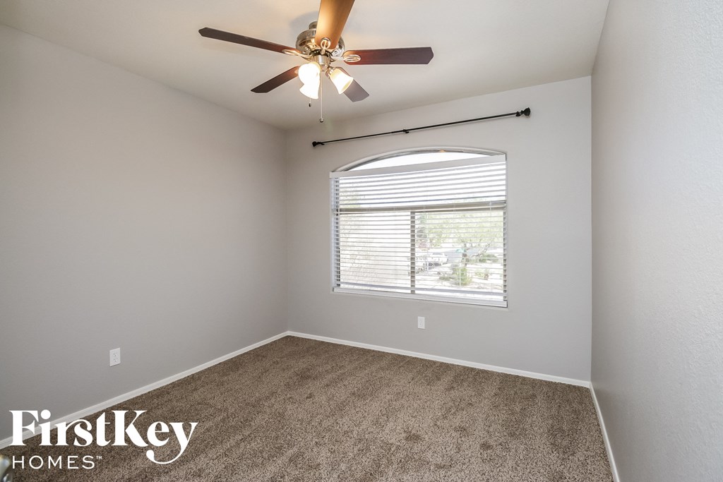 the living room has a large window and a ceiling fan