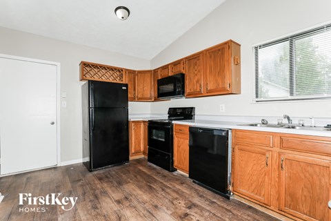 a kitchen with black appliances and wooden cabinets