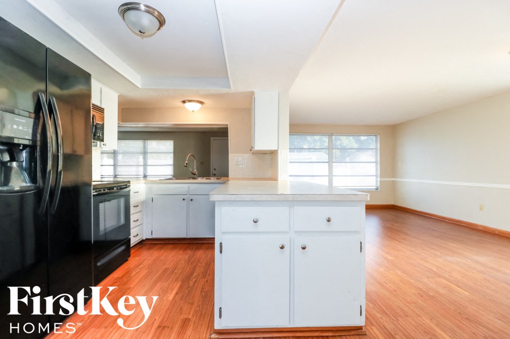 an empty kitchen with white cabinets and stainless steel appliances