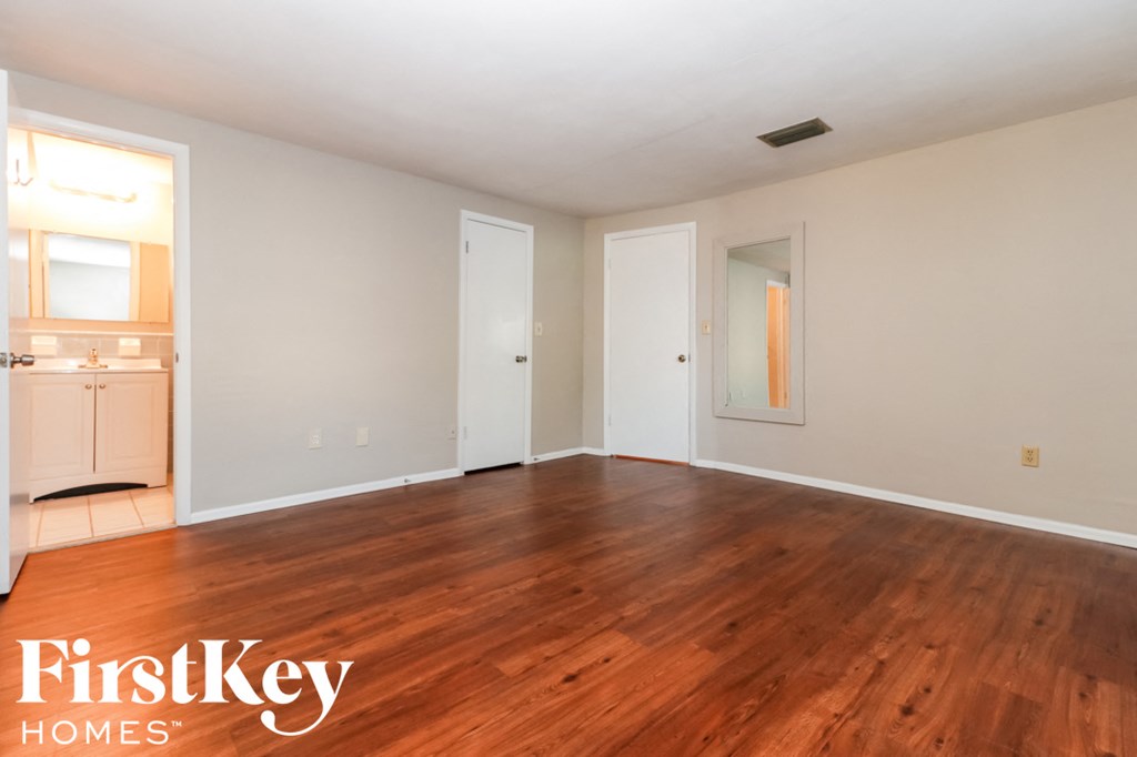 an empty living room with wood flooring and white walls
