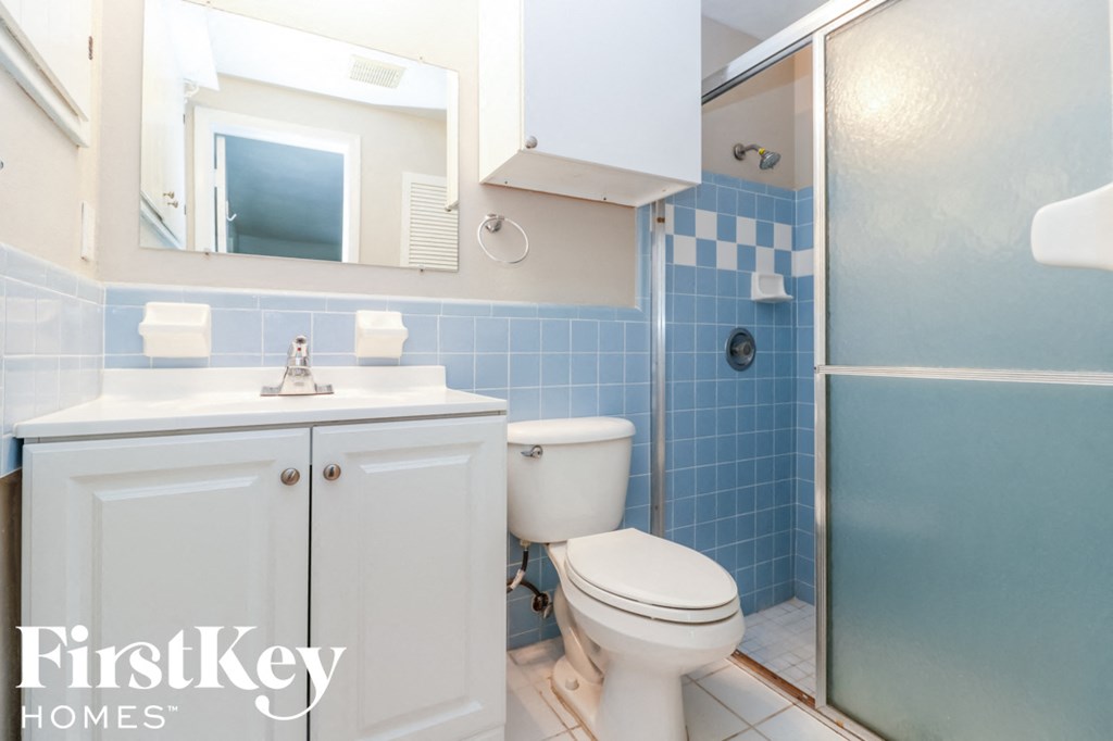 a blue and white bathroom with a toilet sink and shower