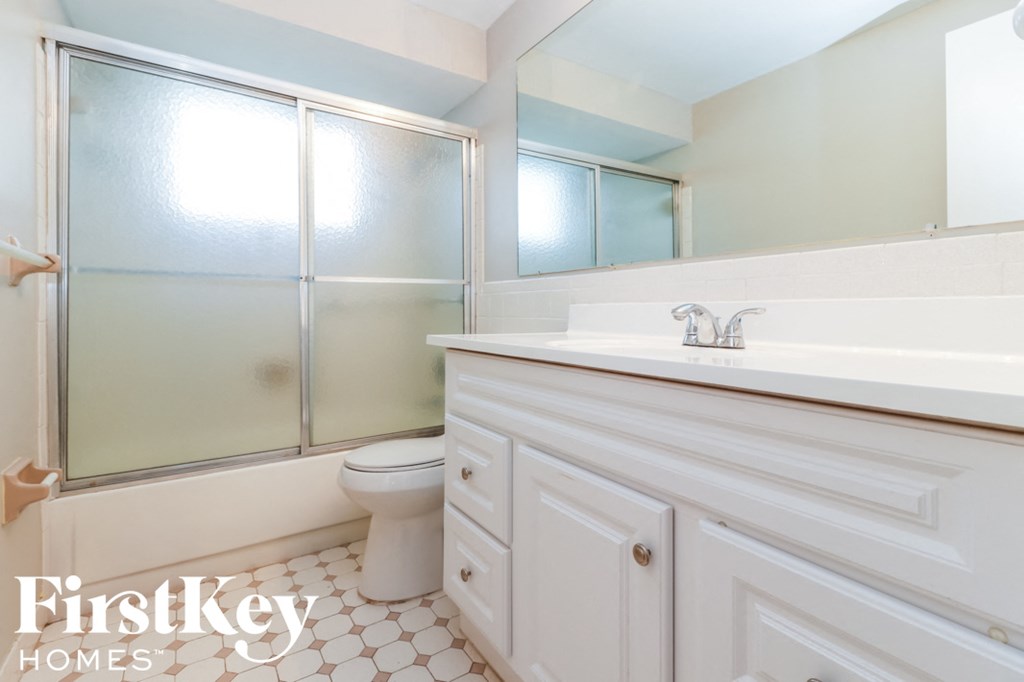 a white bathroom with a toilet and a sink